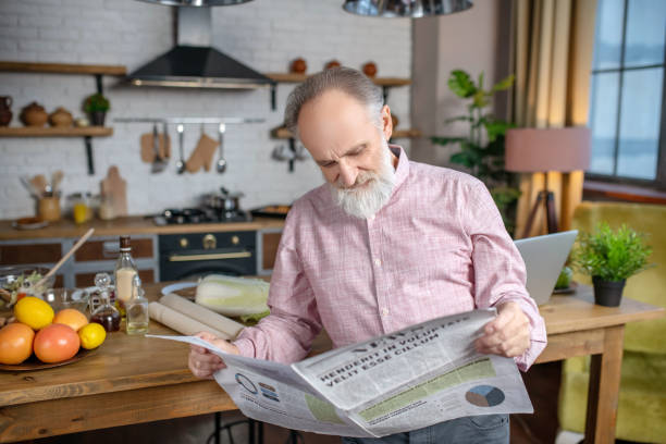 istock Concentrated elderly man reading news in his newspaper 1209299496