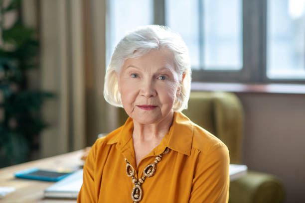 istock Grey-haired elegant woman wearing beads on her neck 1209299548
