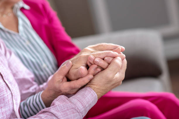 istock Man and woman sitting on the sofa holding each others hands 1209299603
