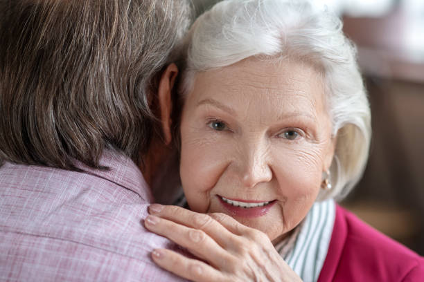 istock Grey-haired woman hugging her husband and looking happy 1209299608