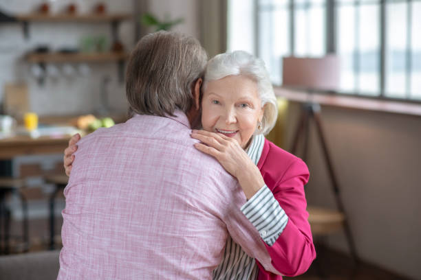 istock Grey-haired woman hugging her husband and feeling happy 1209299621