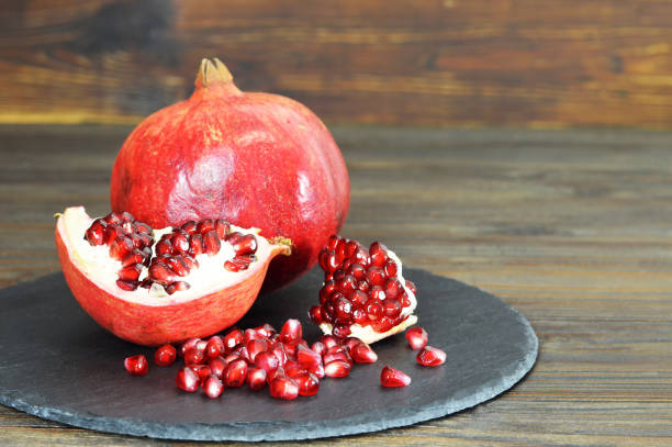istock Ripe pomegranate on wooden background 1209299632