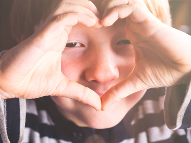 istock Little boy making heart symbol with hands 1209303121