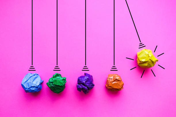 istock Crumpled paper pendulum on pink background - Idea Concept Background 1209304707