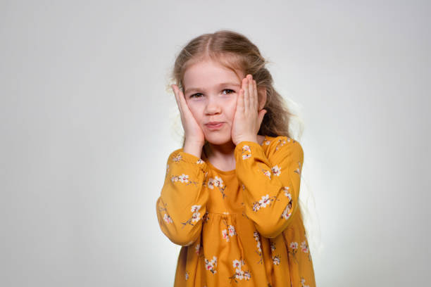istock A little girl holds her cheeks. Childish prank. 1209306659