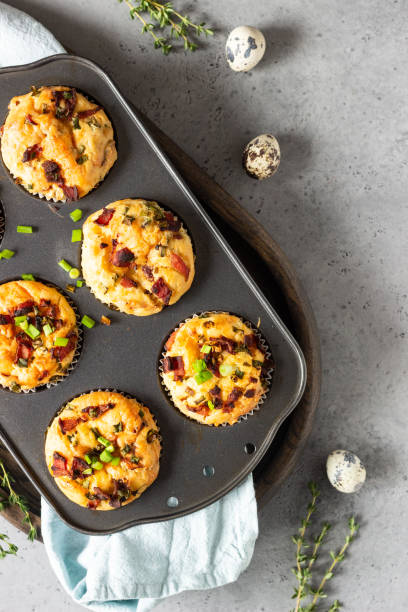 istock Savory muffins with bacon, quail egg, green onion and cheese on a grey stone background. Protein breakfast. Rustic style. 1209307001