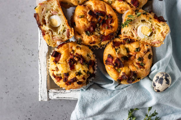 istock Savory muffins with bacon, quail egg, green onion and cheese on a grey stone background. Protein breakfast. Rustic style. 1209307163