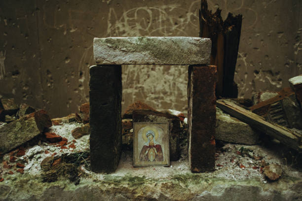 l'icona sfilacciata abbandonata della vergine maria sotto i mattoni che la protegge dall'essere distrutta. rovine della vecchia chiesa vicino a leopoli, ucraina. - church altar indoors dark foto e immagini stock