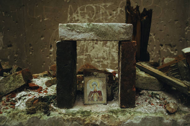 破壊されるのを防ぐことが出来るレンガの下にある聖母マリアの放棄されたほつれたアイコン。ウクライナのリヴィウ近くの古い教会の遺跡。 - church altar indoors dark ストックフォトと画像
