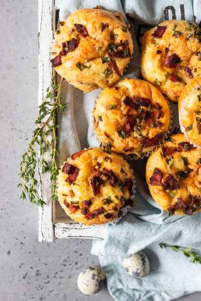 istock Savory muffins with bacon, quail egg, green onion and cheese on a grey stone background. Protein breakfast. Rustic style. 1209308345