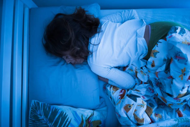 istock Small 11 year old girl sleeping in bed on a stomach. 1209310638