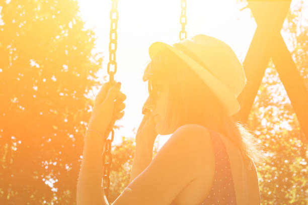 istock Cute young woman enjoying on a swing outdoors in summertime sunlight. 1209311082