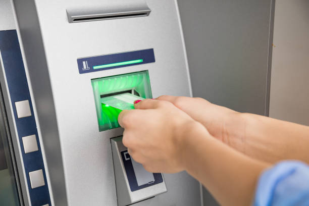 istock Woman using modern ATM machine - cash withdrawal. 1209312235