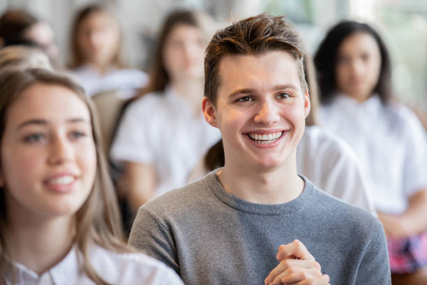 istock Male high school student smiles during conference with his classmates 1209316181