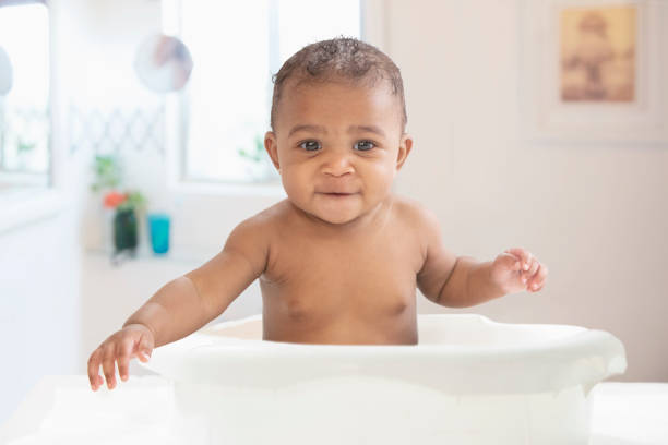 Baby having fun in the bathtub stock photo