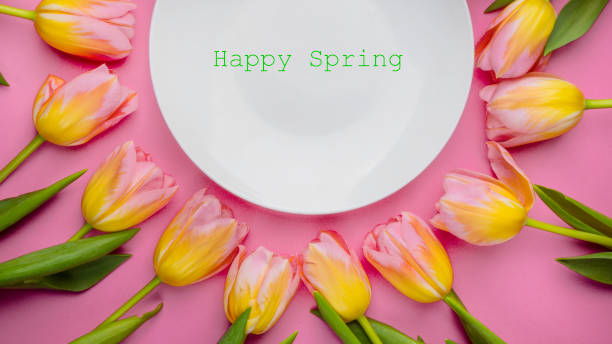 istock Tulips with plate on pink background 1209319462
