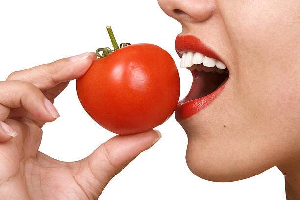 junge frau isst tomaten - beauty in nature women beautiful human teeth stock-fotos und bilder