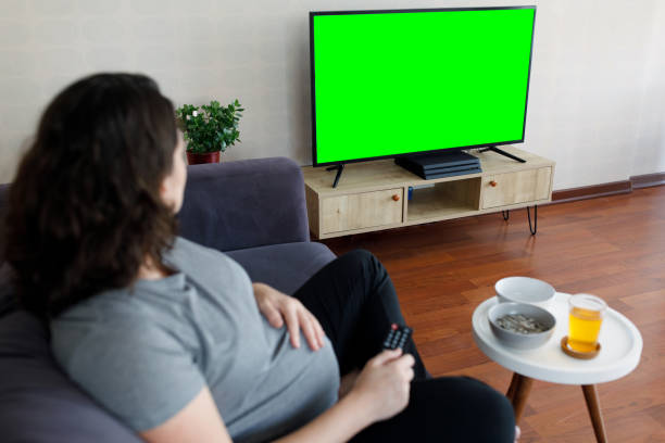 istock Pregnant woman holding remote control 1209321467