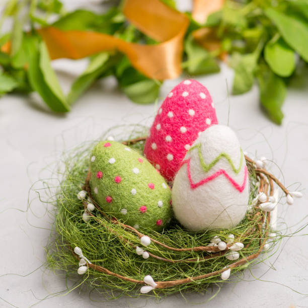 istock decorative colored Ester chicken eggs  in a straw on a white the background. Made of wool 1209324053