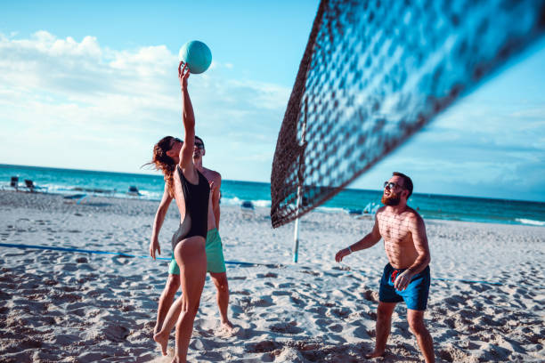 amis jouant au volley-ball de plage - shorts rear view summer beach photos et images de collection