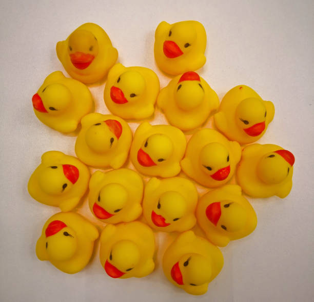 istock Seventeen yellow rubber ducks with black eyes and red beak. View from above. White background 1209335006