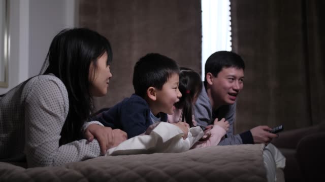 Joyful Asian Family With Kids Watching Film On Tv Stock Video - Download  Video Clip Now - Television Set, Watching, Family - Istock