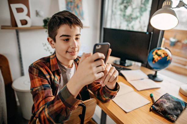 istock Teenage boy using smart phone to send text message 1209341660