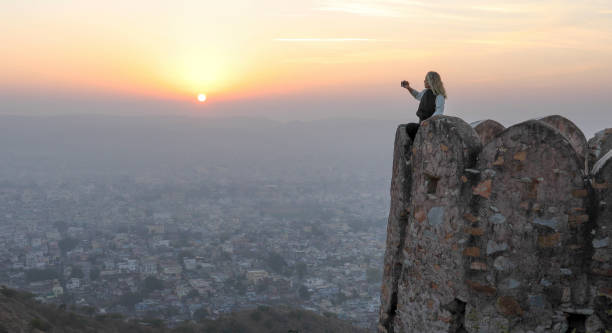 mujer madura toma fotos de la pared del castillo al amanecer - 11323 fotografías e imágenes de stock