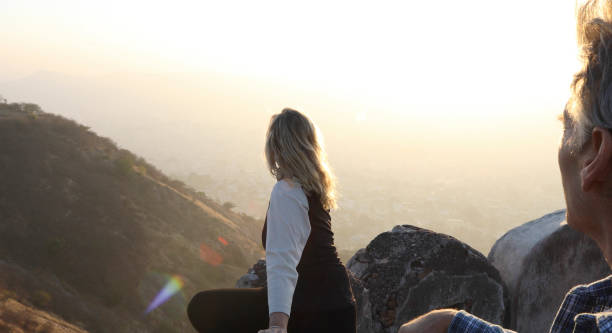 Mature couple look off from castle wall at sunrise