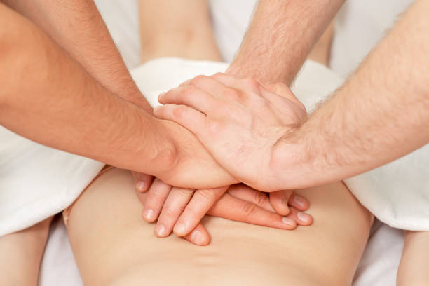 massage du dos à quatre mains. - massage therapist massaging sport beautician photos et images de collection