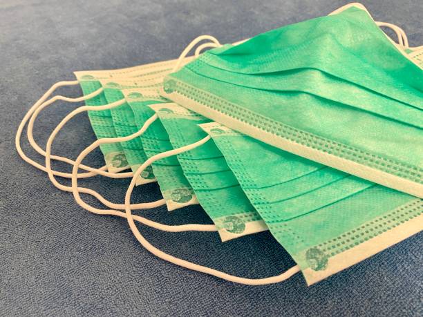 istock Stack of protective mouth masks on blue fabric 1209346747