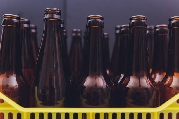 istock Dusty vintage yellow beer crate with empty brown beer bottles on white background. 1209349974