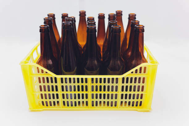 istock Dusty vintage yellow beer crate with empty brown beer bottles on white background. 1209349976
