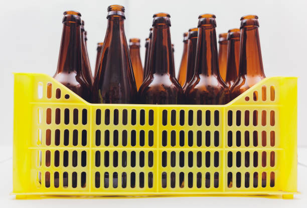 Dusty vintage yellow beer crate with empty brown beer bottles on white background. Dusty vintage yellow beer crate with empty brown beer bottles on white background beer crate stock pictures, royalty-free photos & images