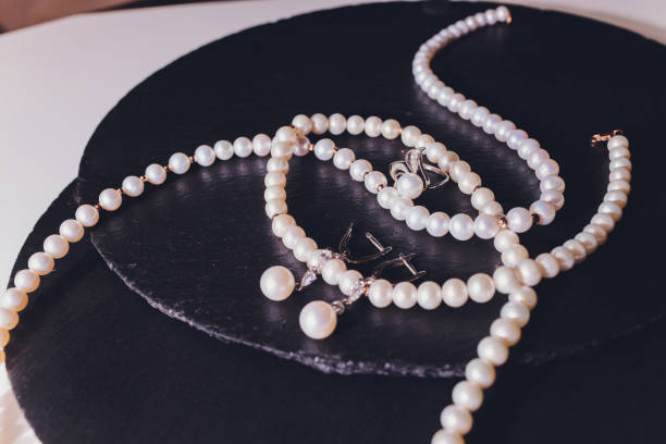 istock white pearl necklace on a black silk close up. 1209350138