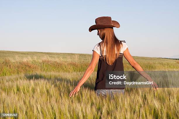 País Menina A Andar Num Campo De Flor Dourada - Fotografias de stock e mais imagens de Chapéu de Cowboy - Chapéu de Cowboy, Vista Traseira, 20-29 Anos