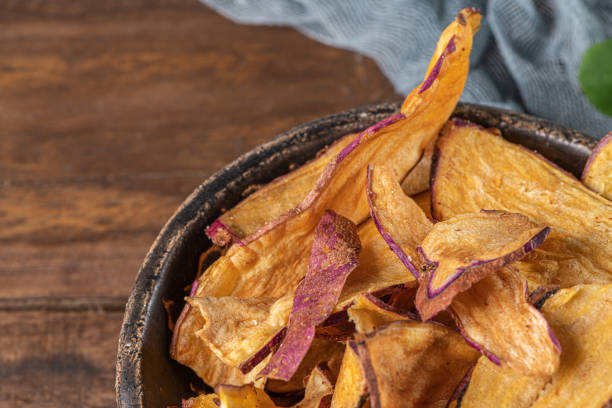 istock Delicious sweet potato chips in bowl, on table. 1209351745