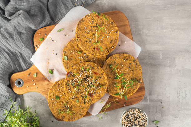 istock Raw veggie burger with lentils, vegetables and thyme leaves on kitchen countertop. Top view. Flat lay 1209351850