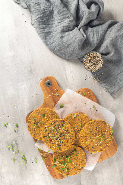 istock Raw veggie burger with lentils, vegetables and thyme leaves on kitchen countertop. Top view. Flat lay 1209352091