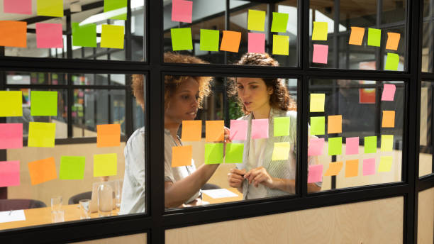istock Focused multiethnic women work on project on colorful stickers 1209353336