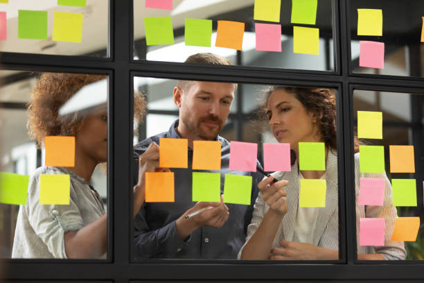 istock Multiethnic colleagues busy writing ideas on post it stickers 1209353340