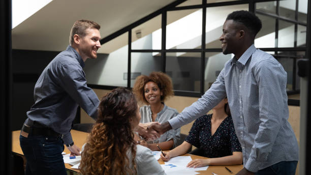 istock Multiethnic male colleagues handshake greeting at briefing 1209353358