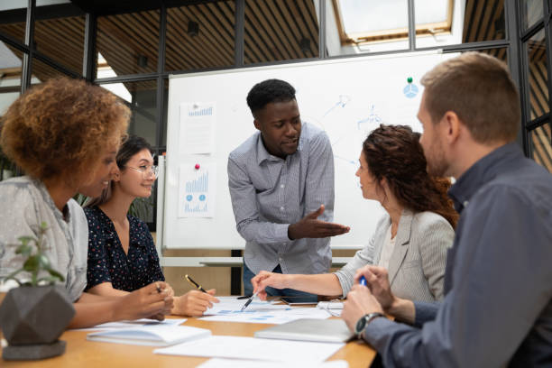 istock Diverse colleagues busy brainstorming discussing paperwork at briefing 1209353360
