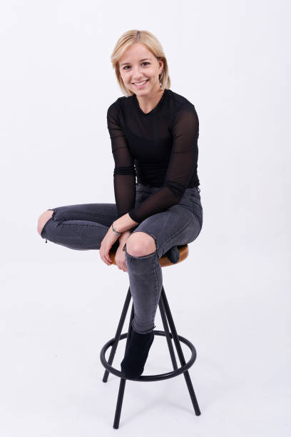 istock Young blond girl sitting on a chair smiling 1209353468