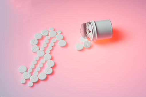 Bottle with medicines lies on a pink background. Pharmacy business, medicine pill concept.Close up and top view.