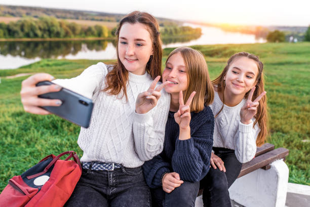 3 девочки подростки 12 13 14 лет, лето, держась за руки смартфона, селфи фото. праздничные выходные, лучшие друзья, эмоции счастья весело улыбают - 13 14 years стоковые фото и изображения