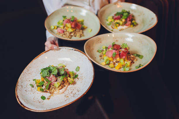 istock Waiter carrying a plate with fish and salad on a wedding. 1209359355