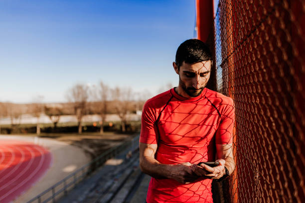 istock young runner man using mobile phone at sunset. Sports outdoors 1209362047