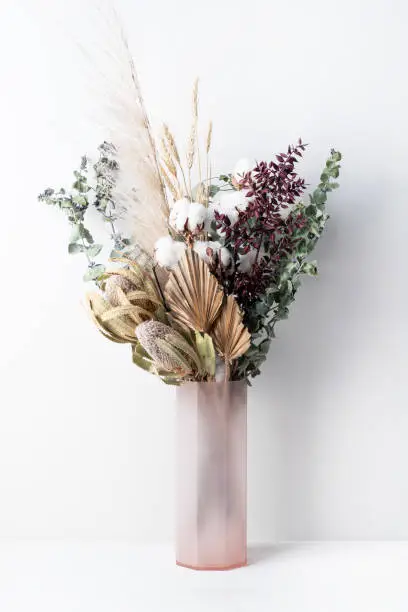 stylish modern dried flower arrangement in a pink vase. Eucalyptus leaves, banksia, cotton flower ,gold palm, pampas grass and ruscus leaves. Art deco Boho gift for Anniversary, birthday, Mother’s Day, Valentine’s Day or any celebration.