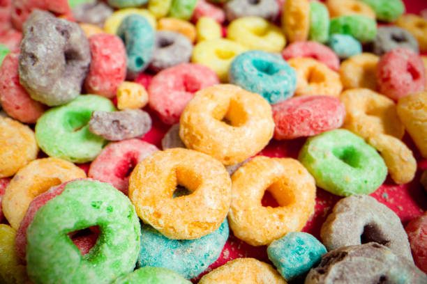 istock Macro Close-Up Wide Angle Shot of Sugary Colorful Fruit Loop American Breakfast Cereal Spread Out on a Red Background 1209364227